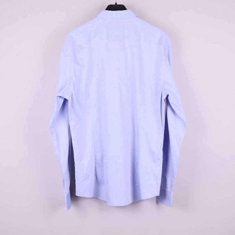 Ljusblå skjorta på galge bakifrån