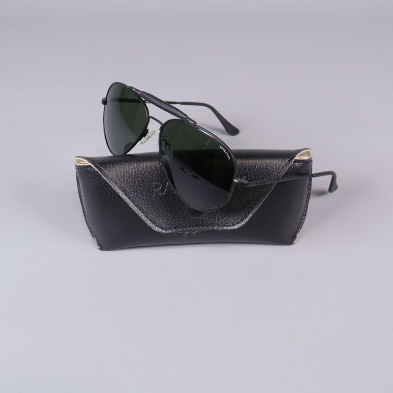 Aviator-solglasögon framför svart fodral med logga