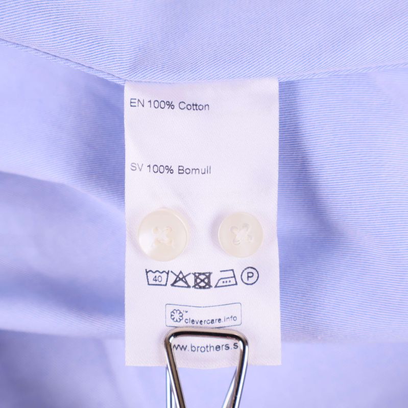 Materialetikett med 100% bomull och extra knappar