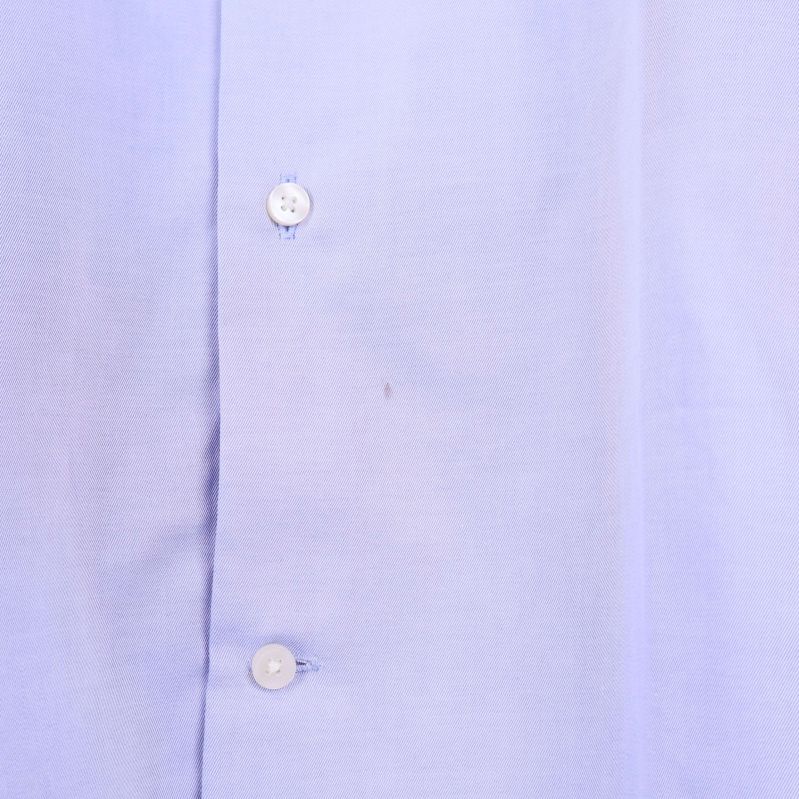 Fläck synlig mellan två knappar på skjortan