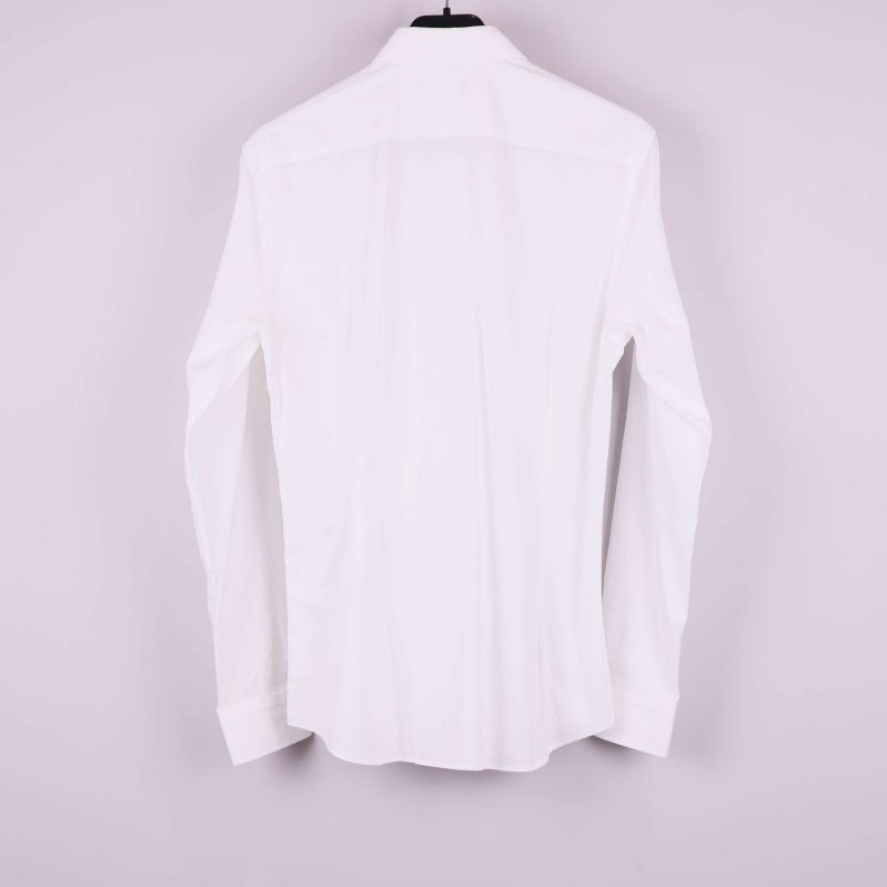 Vit skjorta visad bakifrån på galge