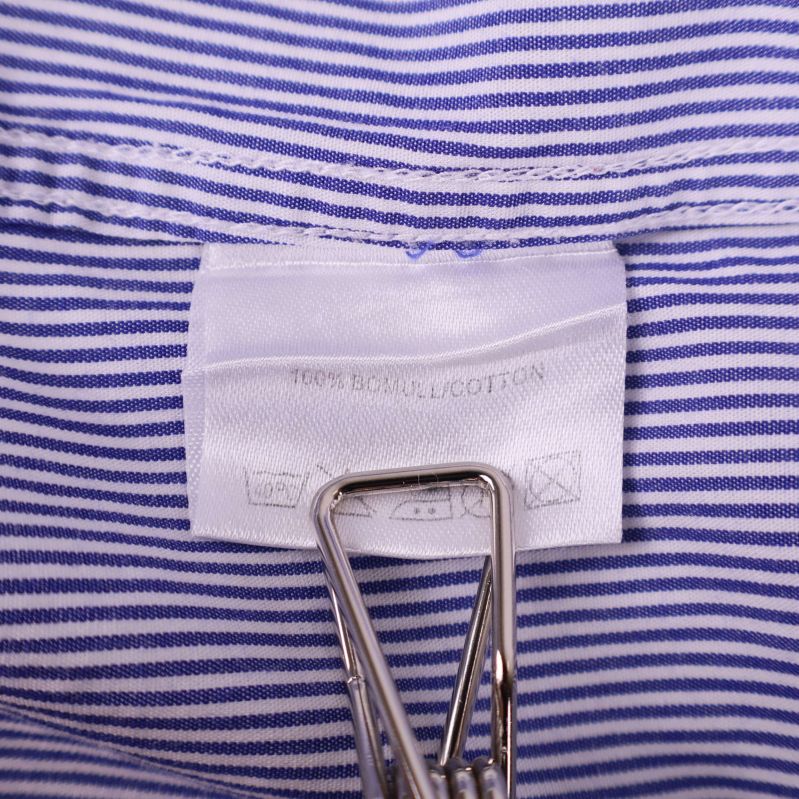 Materiallapp som visar 100% bomull i skjortan