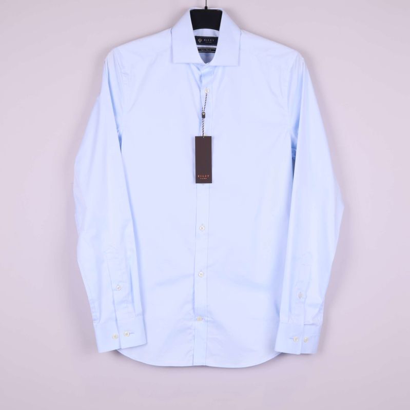 Ljusblå skjorta med lång ärm upphängd på galge