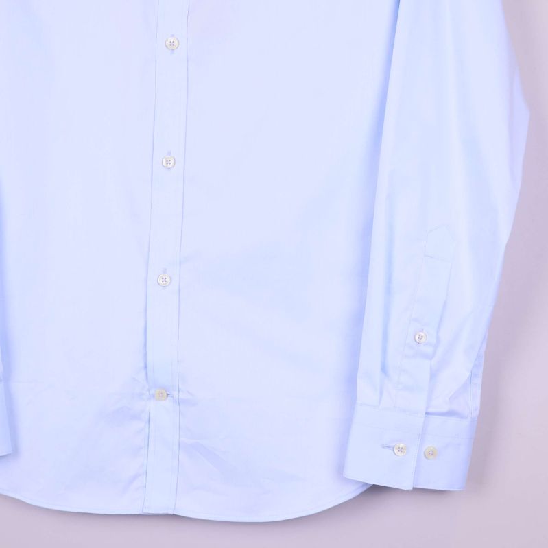 Närbild nedre delen av ljusblå skjorta med manschetter
