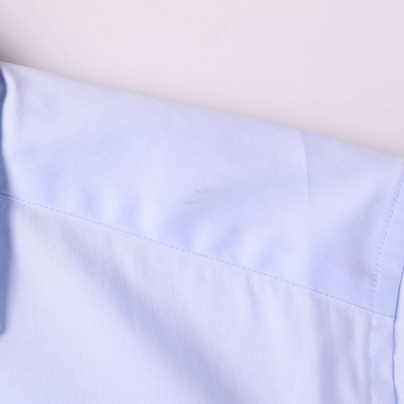 Närbild av lätt fläck på axel på skjortan