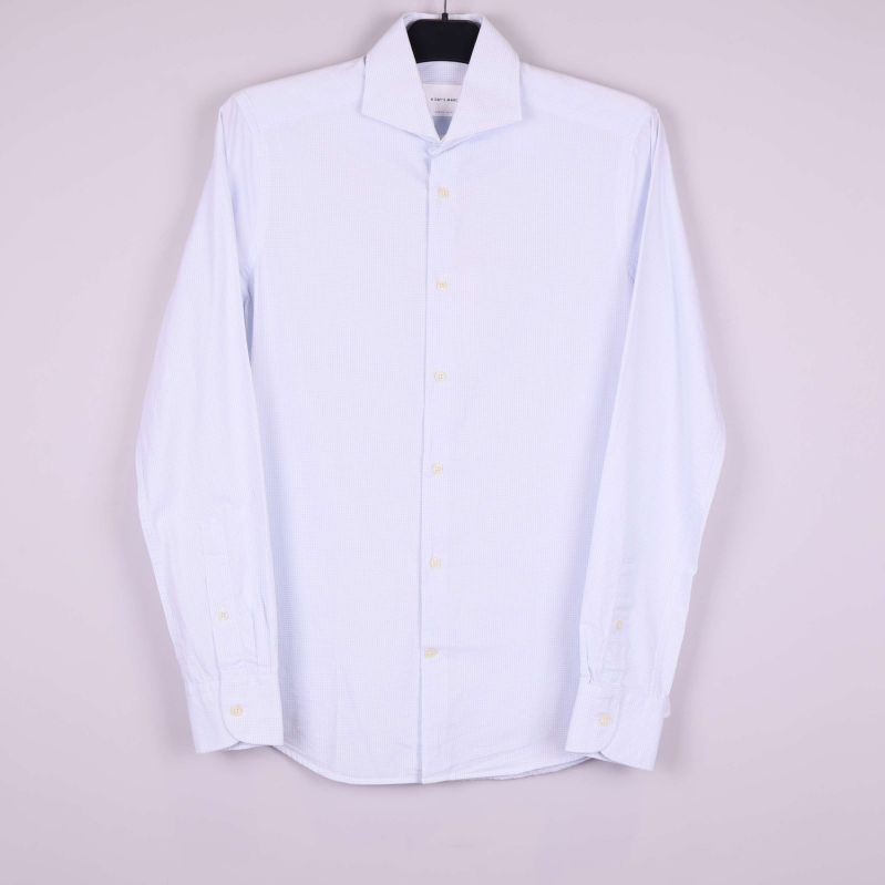 Ljusblå rutig skjorta med lång ärm hänger på galge