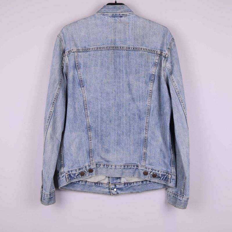 Baksidan av ljusblå jeansjacka mot ljus bakgrund