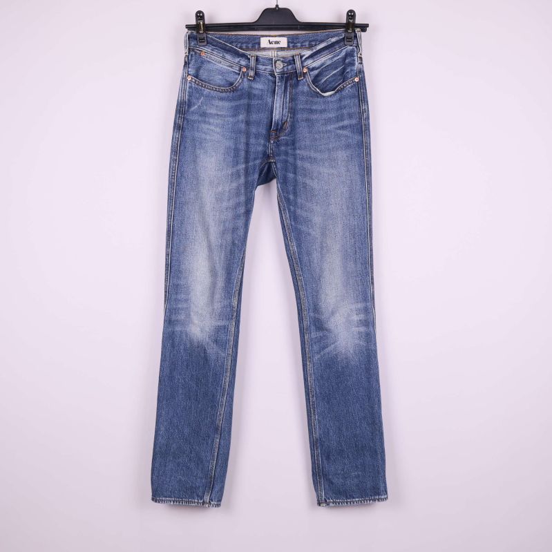 Jeans i ljusblå denim på galge mot vit bakgrund