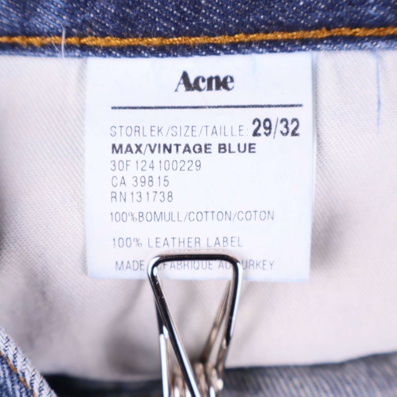 Material- och storleksetikett med information om Acne jeans
