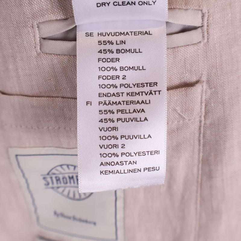 Materialetikett visar 55% linne och 45% bomull, foder i bomull och polyester