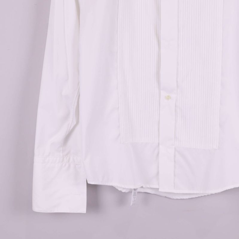 Närbild på skjortans nederkant och ärm med plissering