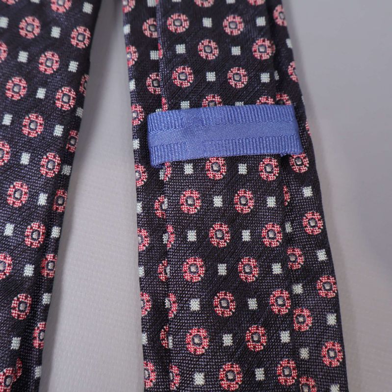 Närbild på blå ögla på slipsens baksida