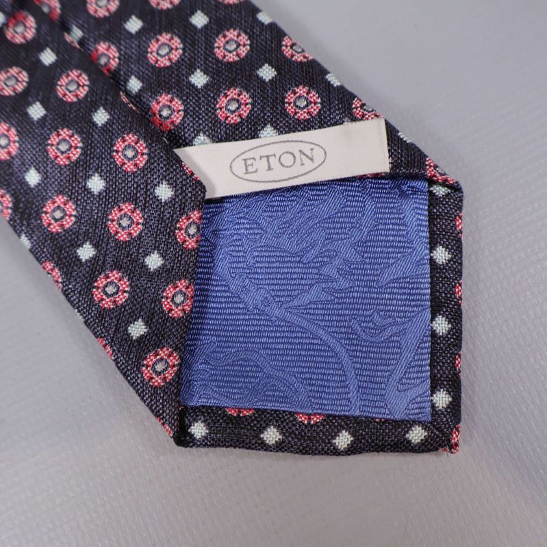 Eton-märke och blå insida i spetsen av slipsen