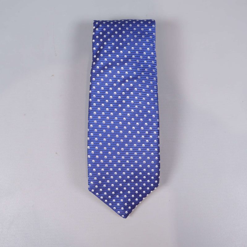 Blå slips med vita prickar, platt mot ljus bakgrund
