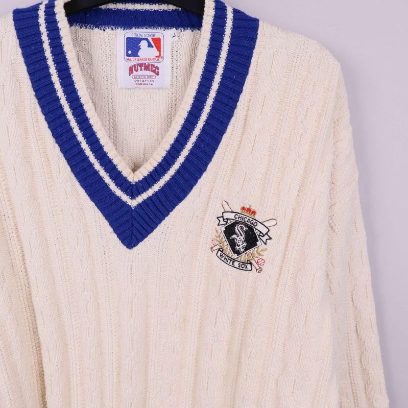 Närbild på blå V-ringning och broderad baseboll-logga