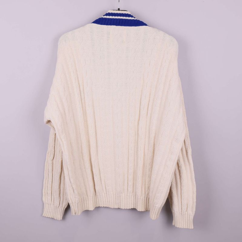 Baksidan av kabelstickad ljus tröja med blå V-ringning