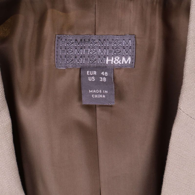 Närbild på H&M-etikett och storlekslapp EUR 48