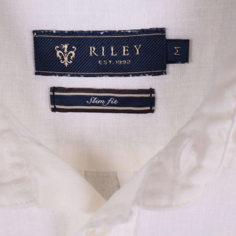 Närbild på RILEY-märke och slim fit-etikett i skjortkrage