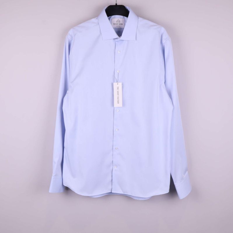 Ljusblå skjorta hänger på galge, framifrån