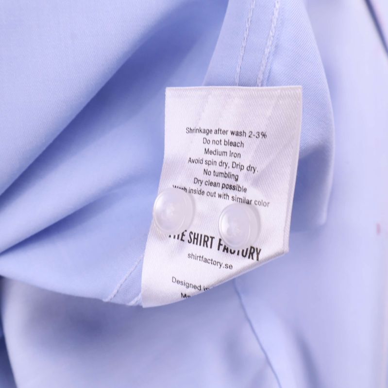 Etikett med skötselråd och extra knappar insydda