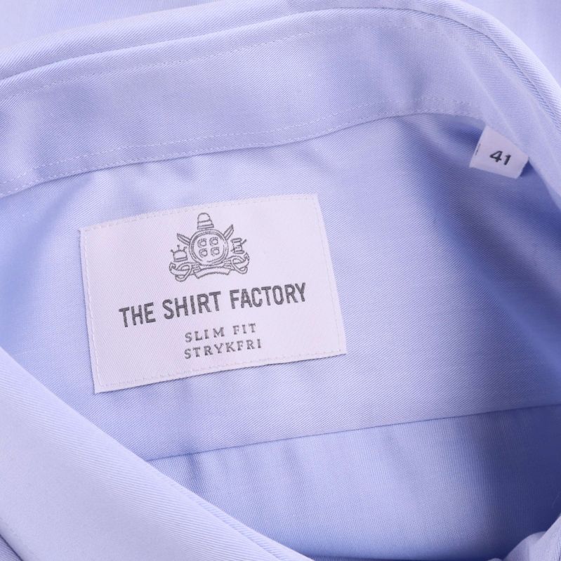 Närbild på varumärkesetikett The Shirt Factory och storlek 41