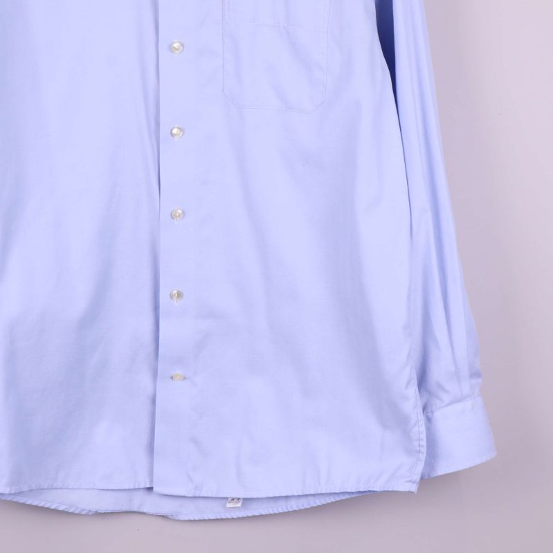 Närbild på nedre delen av skjortans knappslå och fåll