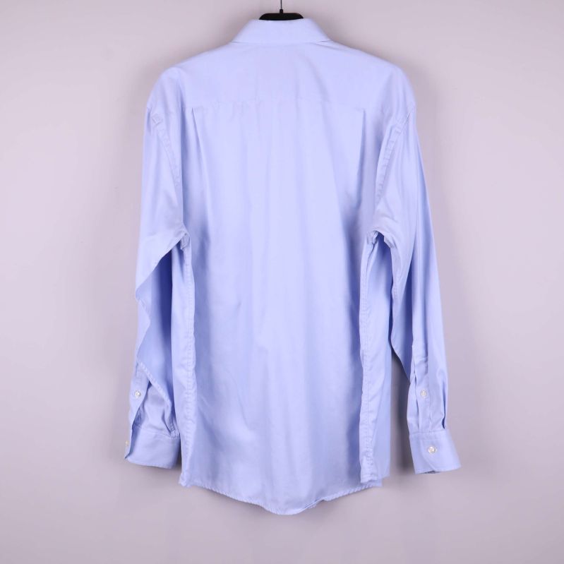 Ljusblå skjorta sedd bakifrån på galge