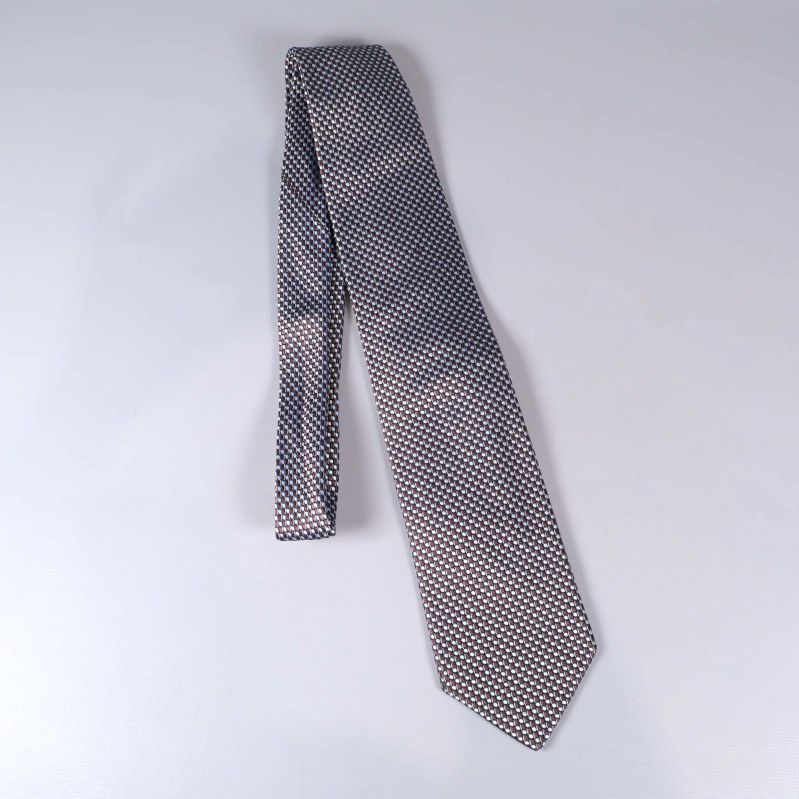 Hel mönstrad slips med bruna och blå detaljer liggande