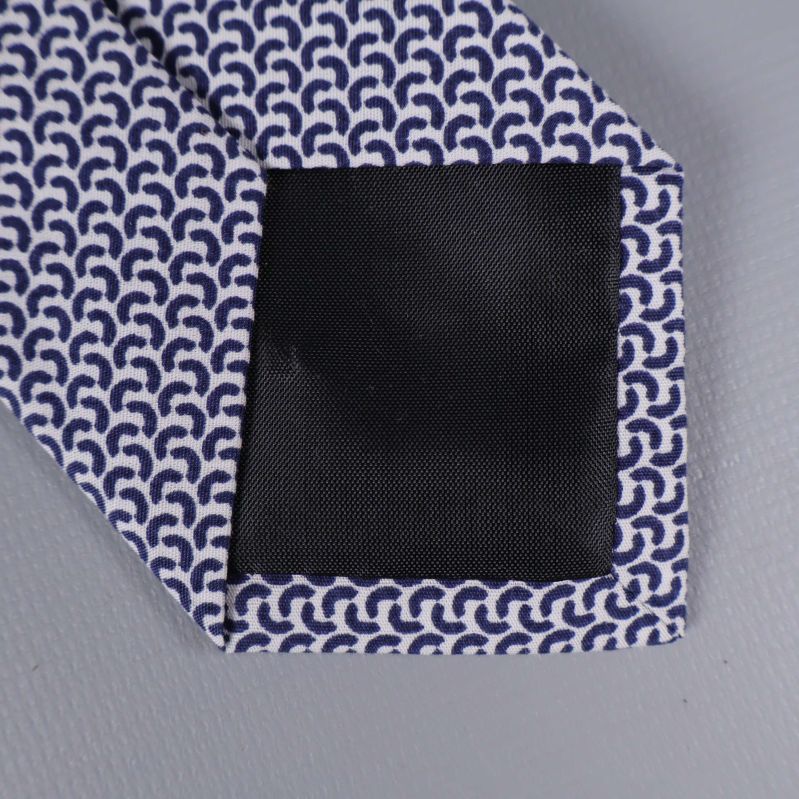 Närbild på slipsens svarta förstärkning i spetsen