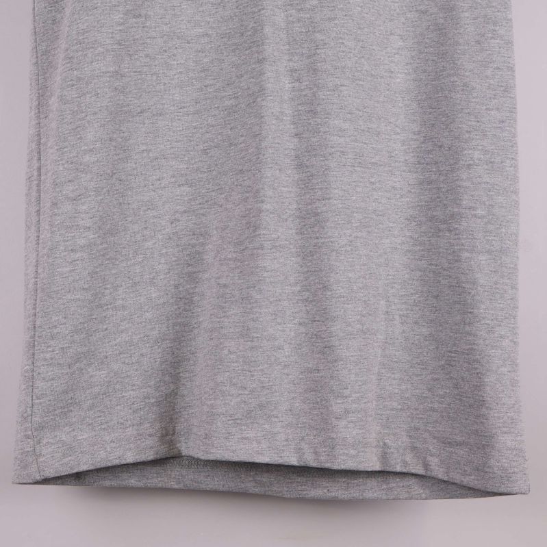 Närbild av t-shirtens nederkant i grått tyg