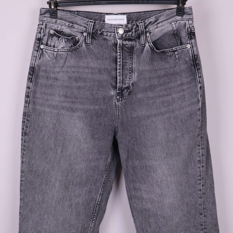 Närbild på överdel och fickor av grå jeans
