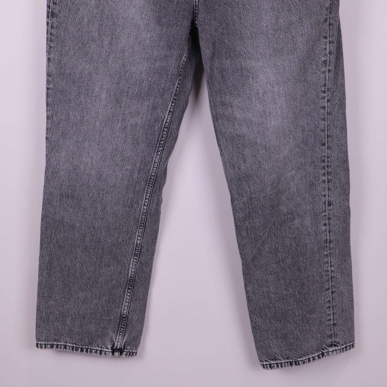 Närbild på ben och fåll av grå jeans