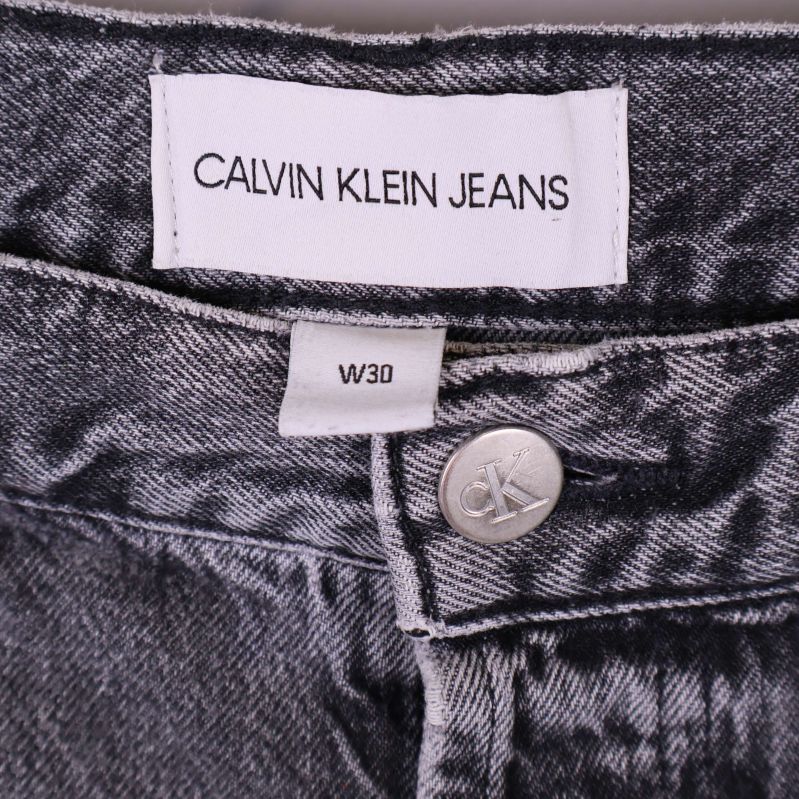 Närbild på Calvin Klein Jeans-märke och storlekslapp W30