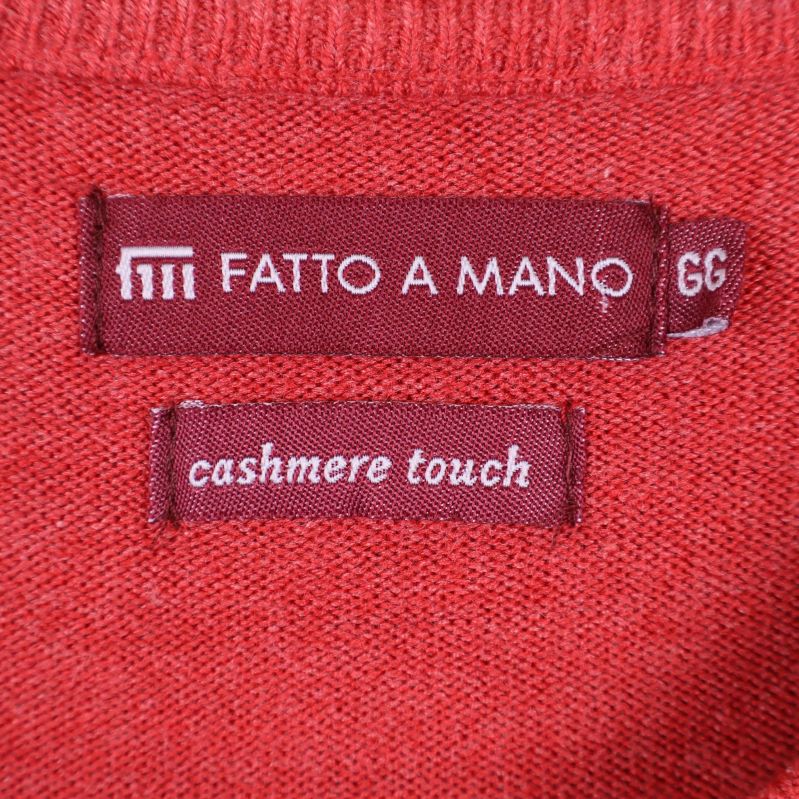 Närbild på etikett med texten fatto a mano och cashmere touch