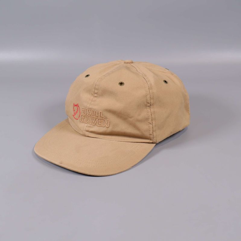 Beige keps med broderad logotyp från sidan