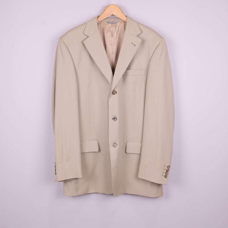 Framifrån syns beige kavaj med slag och fickor