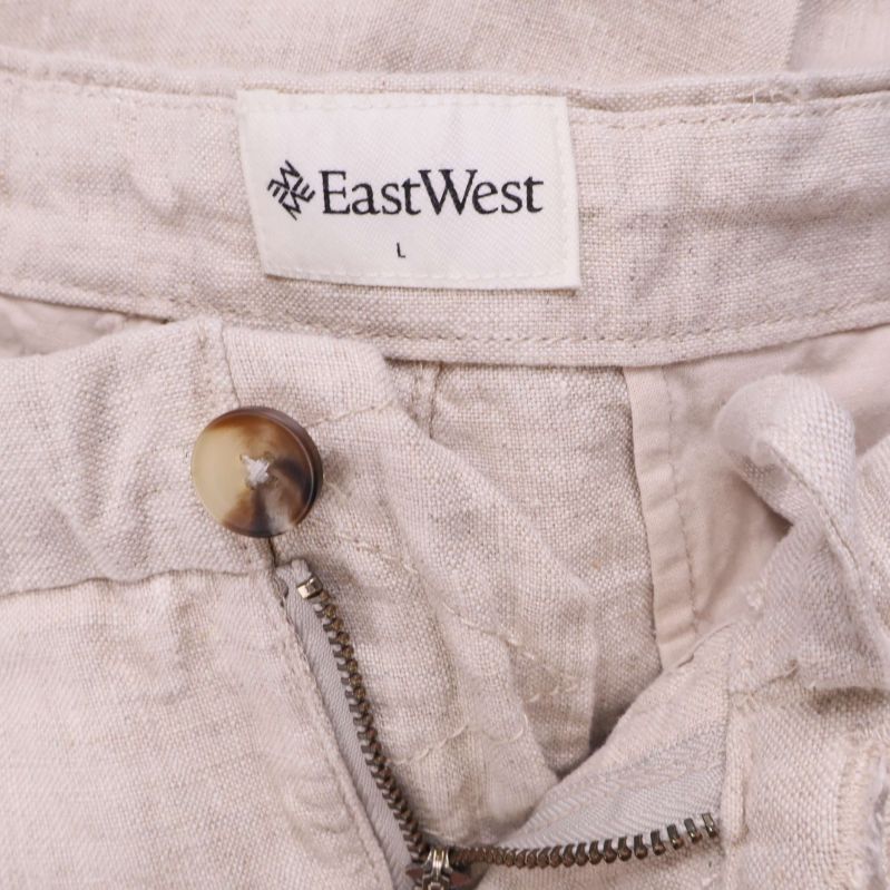 Närbild på knapp och dragkedja med EastWest-etikett