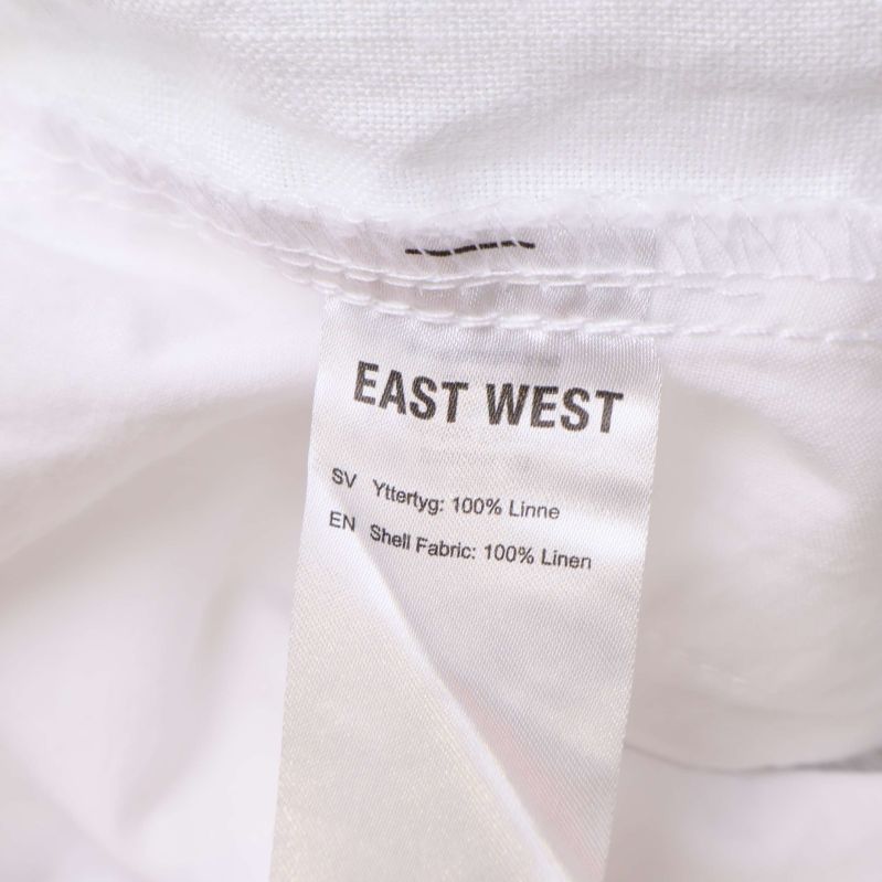Materialetikett med texten 100% linne från East West