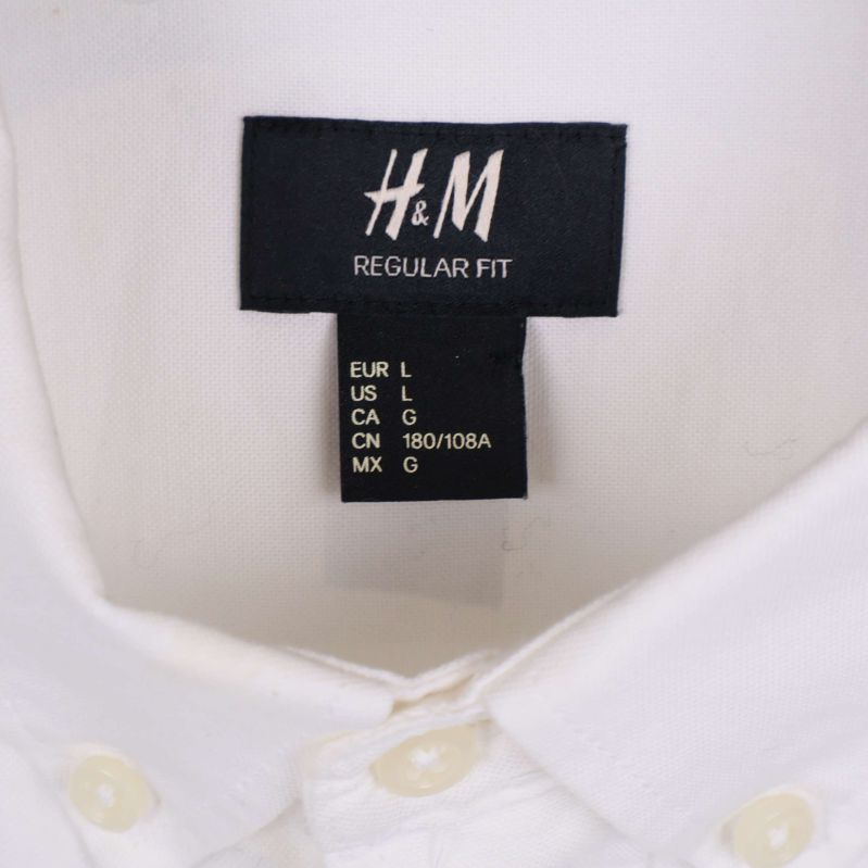 Närbild på H&M-etikett och storlekslapp i skjortan
