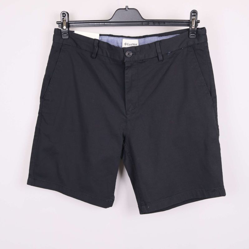 Svarta chinosshorts framifrån på galge