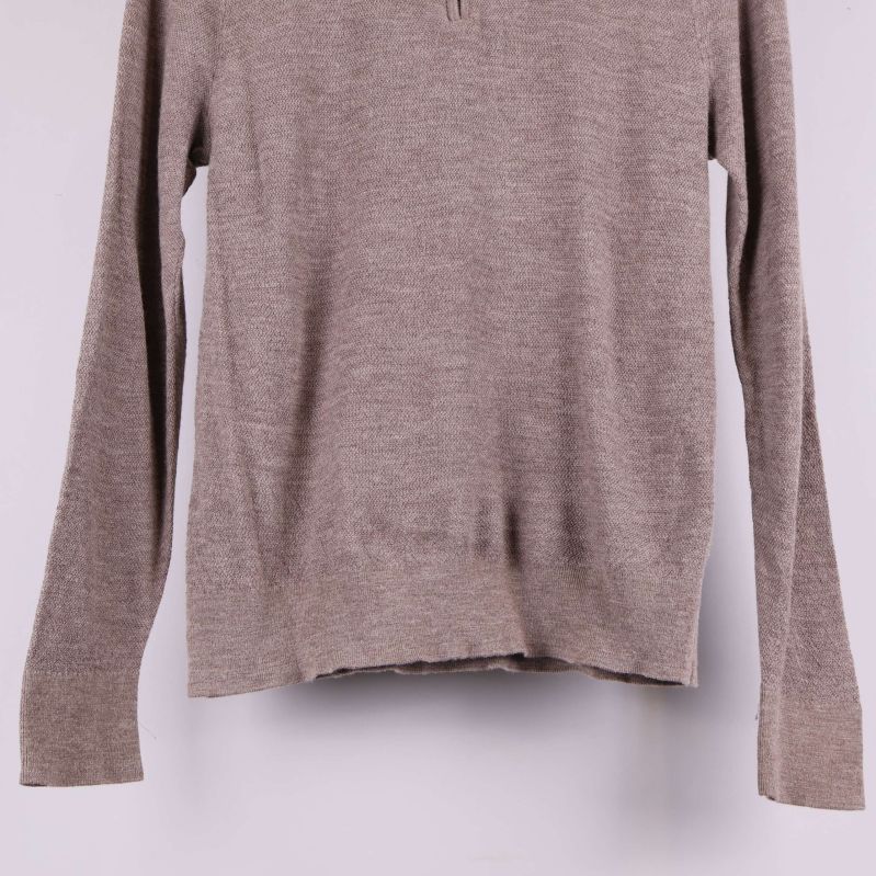 Nederkant och ribbad mudd på beige stickad tröja