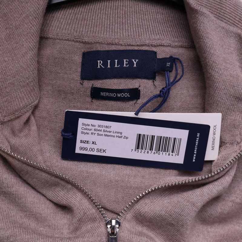 Tröjans halsringning med etikett där det står Riley och Merino Wool