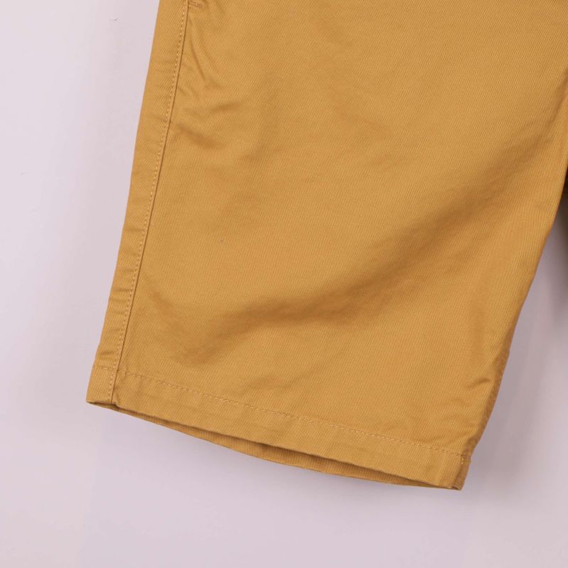 Närbild på benavslut och söm på chinoshorts