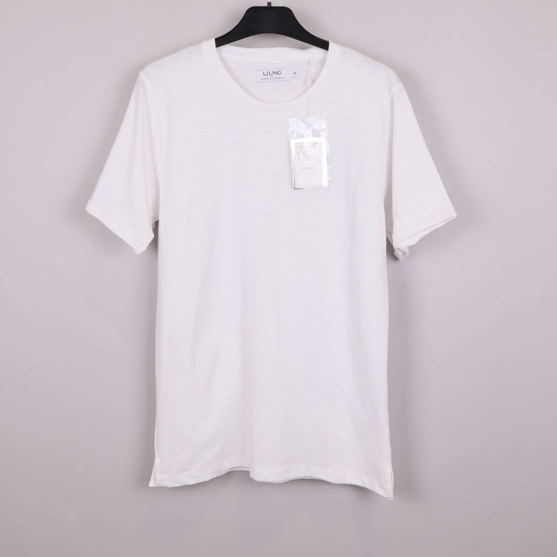 Vit t-shirt på galge mot ljus bakgrund