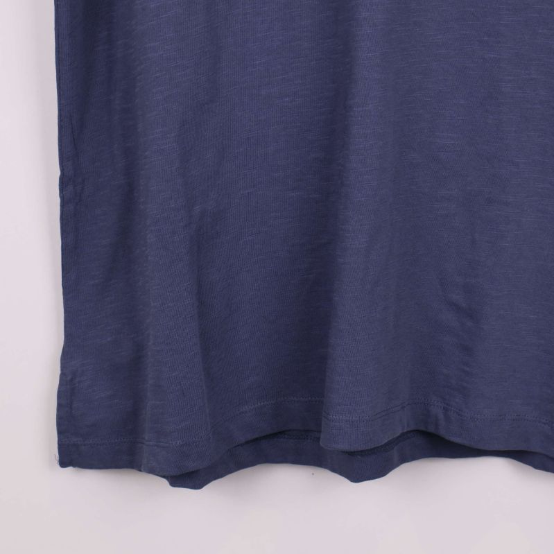 Närbild på nederkant av blå T-shirt