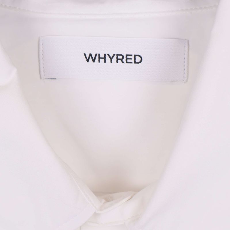 Närbild på Whyred-logotyp i nacken på skjortan