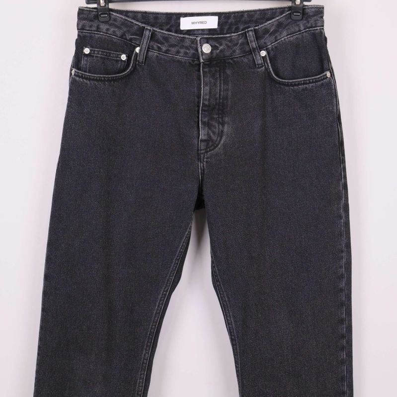 Detaljbild på framsidan av svarta jeans och fickor