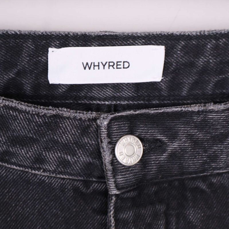 Närbild på Whyred-logotyp och knäppning i midjan