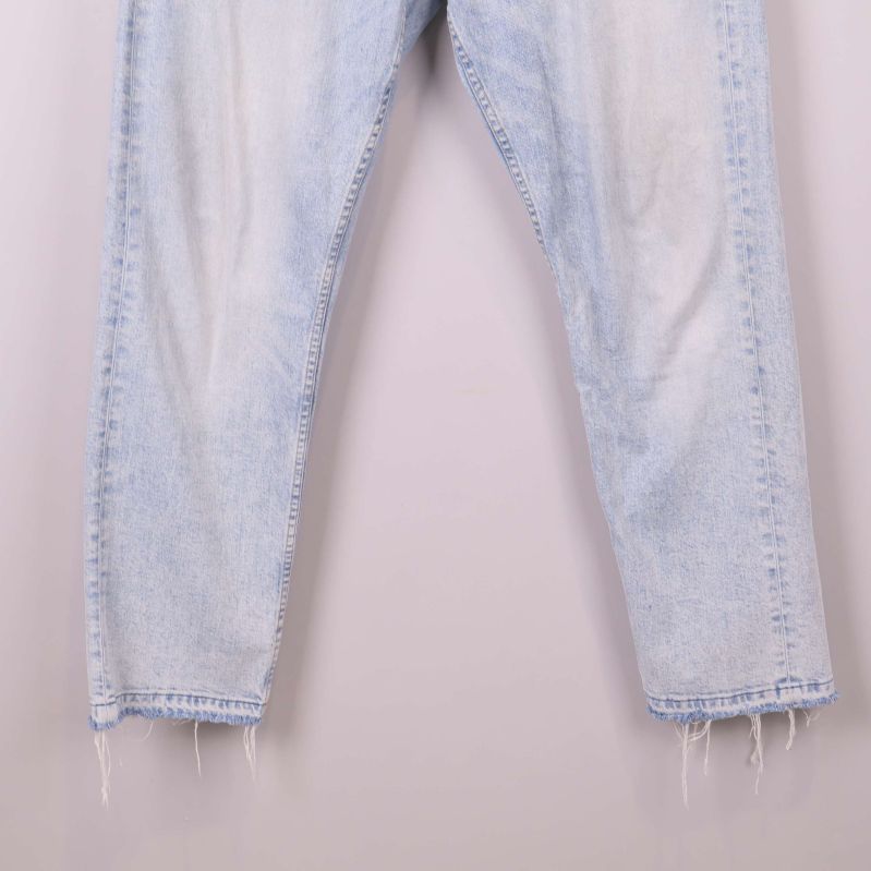 Fransade benslut på ljusblå jeans visas i närbild