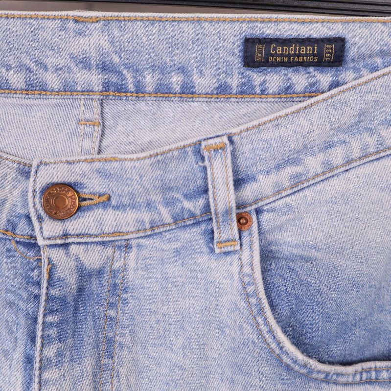 Närbild på midjan och framfickor med etiketten 'Candiani Denim Fabrics'